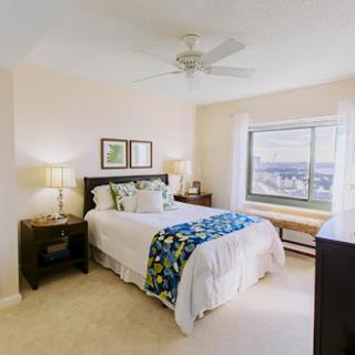 A cozy and well-decorated bedroom featuring a comfortable bed, stylish nightstands, and bright natural light from the window.