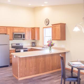 A cozy kitchen with wooden cabinets and a small dining area.