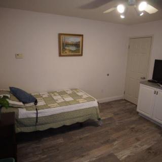 A minimalist bedroom with a single bed, television, and simple decor.