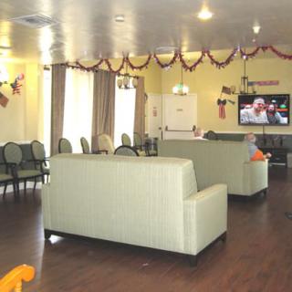 A cozy living room with sofas, a television, and festive decorations.