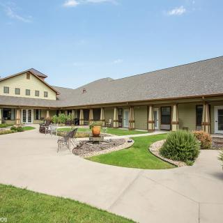 A spacious courtyard featuring a modern building with landscaped pathways and greenery.