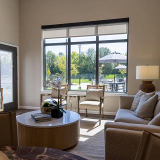 A modern living room with comfortable seating and a large window overlooking a garden.