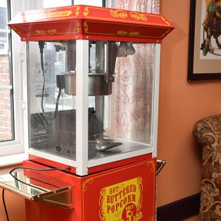 A vintage red popcorn machine placed indoors.