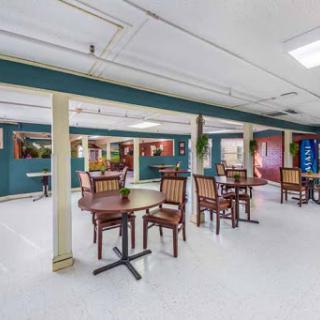 A spacious indoor dining area featuring wooden tables and chairs, perfect for community gatherings.