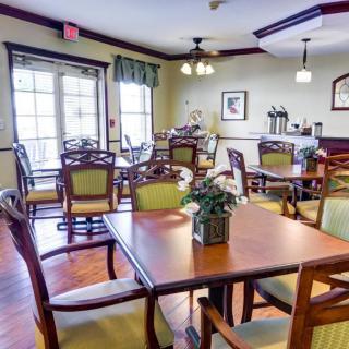 A cozy dining room with wooden tables and chairs, elegantly decorated.