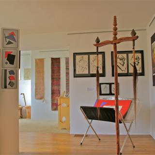 An art gallery showcasing various paintings and sculptures in a bright, open space.