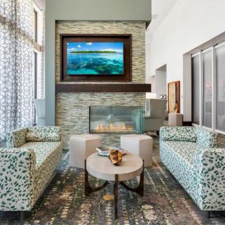 A modern living room with stylish sofas, a fireplace, and a mounted television.