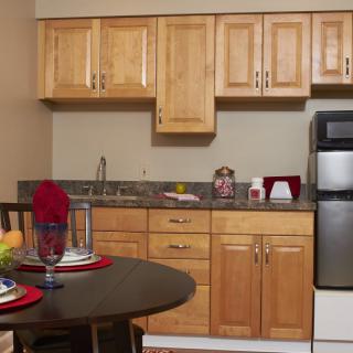 A compact kitchen with wooden cabinets and a small dining area.