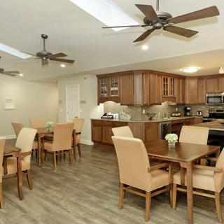 A modern kitchen and dining area with wooden furniture and ceiling fans.