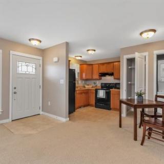 A cozy open floor plan featuring a kitchen with wood cabinets, modern appliances, and an adjacent dining area with a table and chairs.
