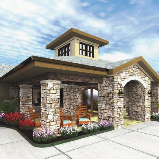 Stone entrance building with landscaping under a cloudy sky.