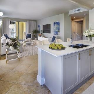 A modern open-plan kitchen and living room with elegant white decor.