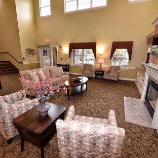 A spacious living room with comfortable seating, a fireplace, and large windows.