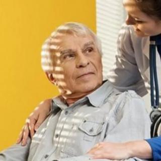 A healthcare professional provides support to an elderly patient.