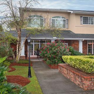 A beautiful two-story house with well-maintained landscaping and a welcoming pathway.