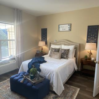 A cozy, well-decorated bedroom with natural light and elegant furnishings.