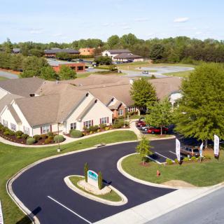 Aerial view of a residential or office complex with surrounding landscaping and parking areas.