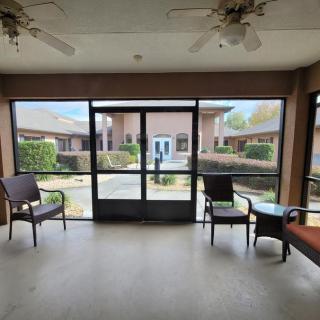 A sunroom with chairs and a table overlooking a courtyard.