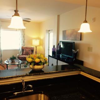 A modern open-space kitchen and living room with elegant pendant lighting.