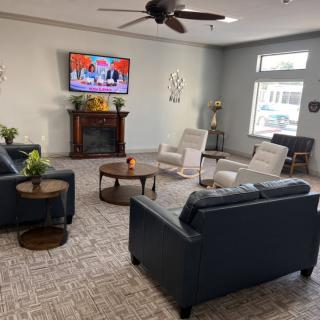 A cozy living room with sofas, a television, and a fireplace.