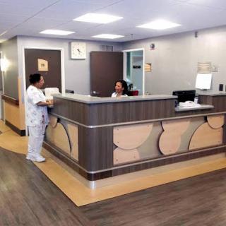 A reception area in a healthcare facility with staff at the front desk.