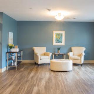 A cozy living room setup featuring stylish chairs and a modern coffee table against a serene blue wall.
