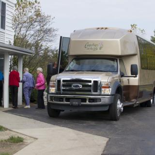 A group of people boarding a bus parked outside a building.