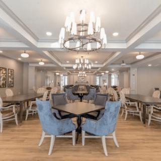 A modern dining area featuring elegant chandeliers, comfortable seating, and sleek tables.