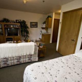 A cozy room featuring a bed and a living area with a television and sofa.