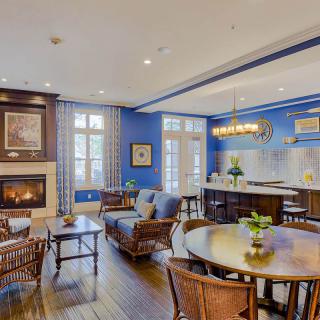 A modern open-concept living space featuring a cozy fireplace, blue walls, and elegant kitchen and dining areas.