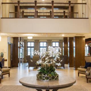 A spacious and elegantly designed lobby with modern furniture and a central floral arrangement.