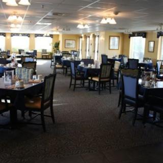 An empty restaurant dining room with neatly arranged tables and chairs.