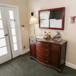A cozy entrance with a wooden sideboard, decorated with a lamp and mirror.