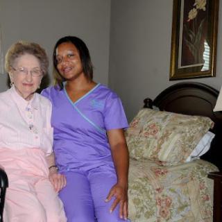 A warm moment shared between an elderly resident and her caregiver in a cozy living space.
