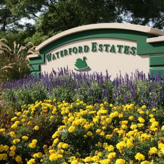 Entrance sign of Waterford Estates surrounded by vibrant flowers.