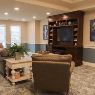 A cozy and elegantly designed living room featuring a comfortable seating area, a large TV, and stylish decor.