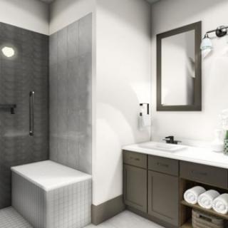 A modern bathroom with a walk-in shower, sink, and neatly arranged towels.