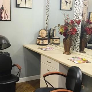 A cozy hair salon setup with a styling chair, mirror, and decorative elements.