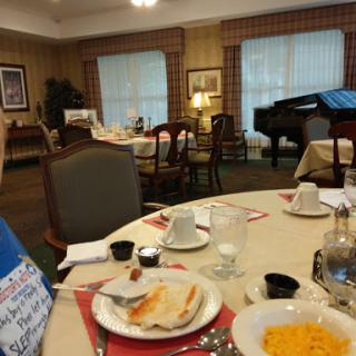 A cozy dining area set for breakfast, featuring a piano and a warm atmosphere.