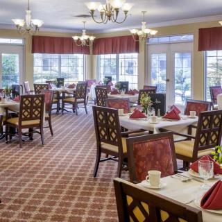 A spacious dining room with elegantly set tables and comfortable seating.
