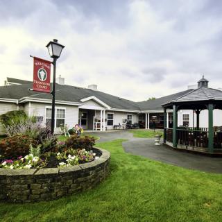 A scenic view of a building with a surrounding garden and gazebo.