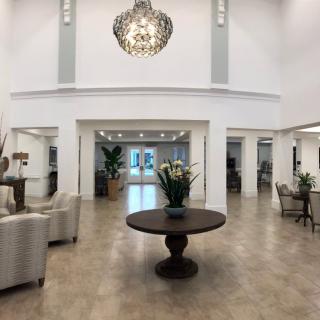 A spacious and elegantly decorated lobby with modern furniture and a striking chandelier.