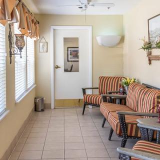 A cozy indoor seating area with striped chairs and large windows.