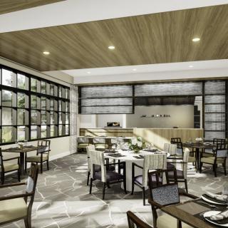 A modern restaurant interior with ample natural lighting, featuring neatly arranged tables and chairs.