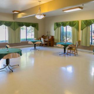 A spacious and quiet indoor seating area with tables and green curtains.