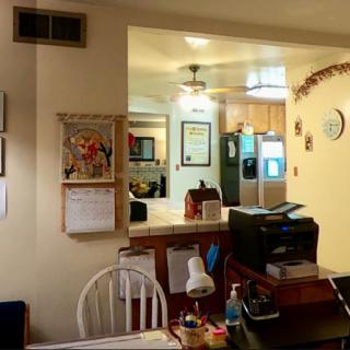 A cozy home interior featuring a small office desk area adjacent to the kitchen and dining space.