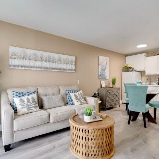 A modern living room with a comfortable sofa, a stylish coffee table, and an adjacent dining area.