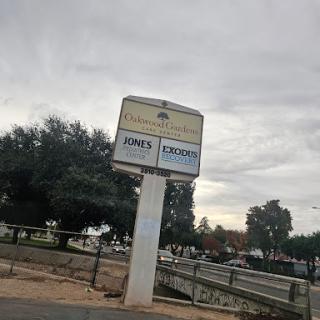 A business sign displaying 'JON'S EXCAVATION' against a cloudy backdrop.
