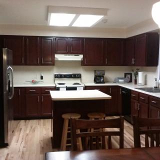 A modern kitchen with dark wooden cabinets and a central island.
