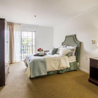 A cozy bedroom with elegant decor and a view of the balcony.